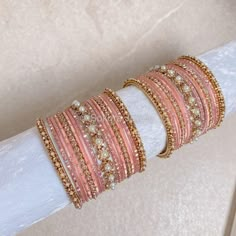 2 Small stacks of Antique Gold bangles with Pearl and gold stonework details finished with pretty pinks and our favourite Daisy Bangle in the centre to add that sparkle. Ready to Ship! Packed in small box ( no roll ) Pink Stackable Beaded Bracelets For Party, Pink Stackable Bangle For Party, Stackable Pink Bangle For Parties, Pink Beaded Bangle Bracelets For Wedding, Pink Stackable Bangle As Gift, Adjustable Pink Stackable Bangle, Pink Stackable Jewelry For Festive Occasions, Adjustable Stackable Pink Bangle, Elegant Pink Beaded Bracelets For Festive Occasions