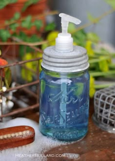 a jar with a toothbrush on top of it next to plants and other items