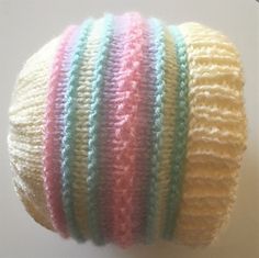 a multicolored knitted hat is shown on a white surface