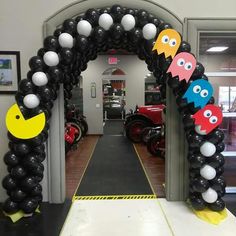 an entrance decorated with black, white and yellow balloons that look like pacmanes