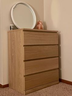 a dresser with a mirror on top of it in a corner next to a wall