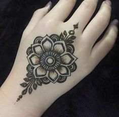 a woman's hand with a henna tattoo on it