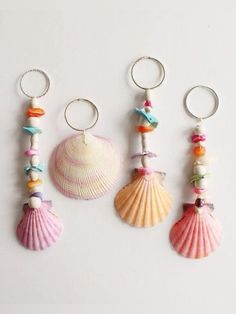 three seashells are hanging on the wall next to each other with beads and charms