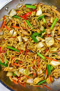 stir fried noodles with chicken and vegetables in a wok