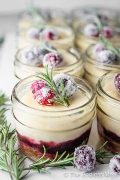 small jars filled with desserts covered in powdered sugar and cranberry sauce