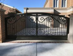 an iron gate in front of a brick house