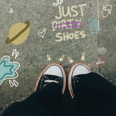 someone's feet are standing on the sidewalk with colorful stickers all over them