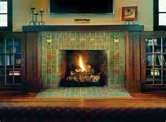 a fire place in a living room with bookshelves and a television above it