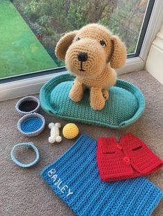 a stuffed dog sitting on top of a blue tray next to other crocheted items