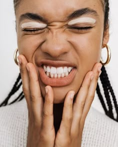 a woman smiling with her hands on her face