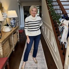 a woman is standing on a rug in the hallway