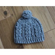 a blue knitted hat sitting on top of a wooden floor