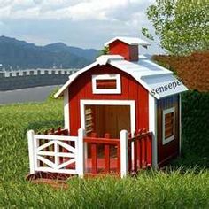 there is a small red and white dog house in the grass