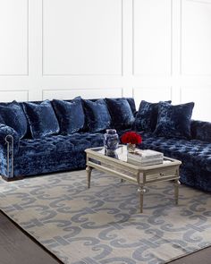 a blue couch sitting on top of a rug in a living room next to a coffee table