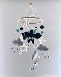 a mobile with stars, moon and clouds hanging from it