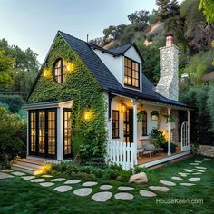 a white house with green ivy growing on it's roof and windows, surrounded by stepping stones