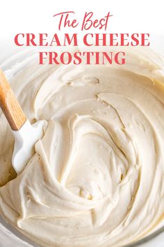 a bowl filled with white frosting and a wooden spoon