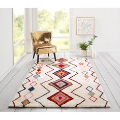 a white area rug with multicolored geometric designs on the front and back of it