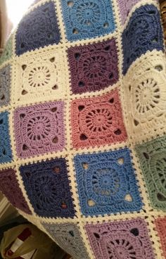 a crocheted blanket sitting on top of a chair