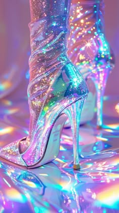 a pair of high heeled shoes sitting on top of a shiny floor covered in colorful lights