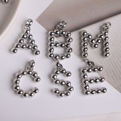 -------Silver plated Alphabet Letter Pendant, Elegant Round Beaded Fashion Pendant, Necklace Jewelry Accessories   Material: Metal Copper, Silver Plated Color: Gold color Size: Approx. 30mm in length Quantity: 10 Pieces / 26 Pieces Pendant Shape: A-Z Letter   Conversion : 1 inch = 25.4mm or 1mm = 0.0393 inch More style electroplating Micro Pave zircon beads & pendants charms, please view the BELOW listing: https://www.etsy.com/shop/Albertbeads?ref=listing-shop2-all-items-count&section_id=21546235 Welcome to our store! https://www.etsy.com/shop/Albertbeads Silver Jewelry With Charms And Round Beads, Silver Jewelry With Round Bead Charms, Silver Necklace With Letter Beads, Silver Round Pendant Charms, Personalized Silver Necklaces With Round Beads, Silver Necklaces With Personalized Round Beads, Silver Sterling Silver Necklace With Letter Beads, Silver Metal Round Pendant Charm, Personalized Silver Metal Charms