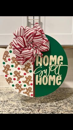 a christmas ornament hanging from the side of a kitchen counter with a bow on it