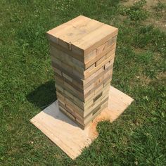 a stack of wooden blocks sitting on top of a green field