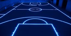 an indoor basketball court lit up with blue lights