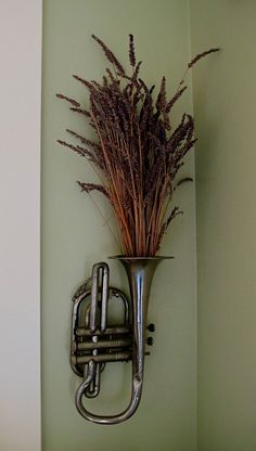 there is a metal trumpet and some plants in it