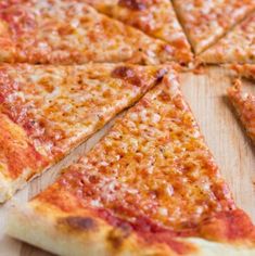 a sliced pizza sitting on top of a wooden cutting board