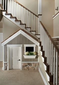 a dog house under the stairs with flowers on it's shelf in front of the door