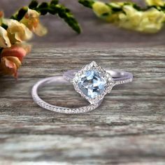 an engagement ring with a blue topazte surrounded by flowers