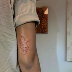 a man's arm with a tattoo on it that has a cow drawn on it