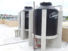 two large black tanks sitting on top of a roof