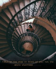 a man sitting on top of a spiral staircase