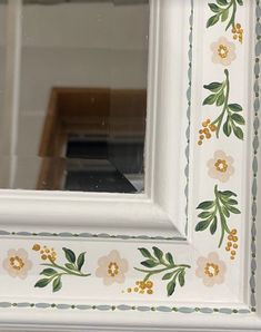 a white frame with flowers painted on it