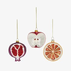 three ornaments in the shape of pomegranates