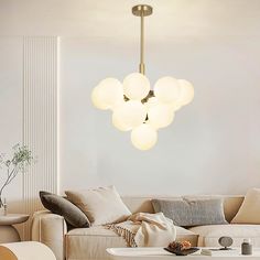 a living room filled with furniture and a light fixture hanging over the top of it