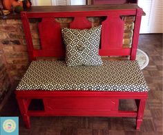 a red bench with black and white pillows on it