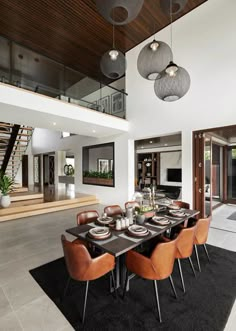 a dining room table and chairs in front of a staircase leading to an open floor plan