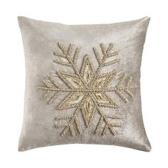 a silver pillow with an embroidered snowflake on it