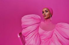 a woman in a pink dress sitting on a chair