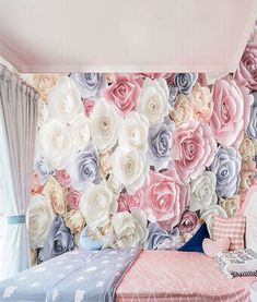 a bedroom decorated in pastel colors with flowers on the wall