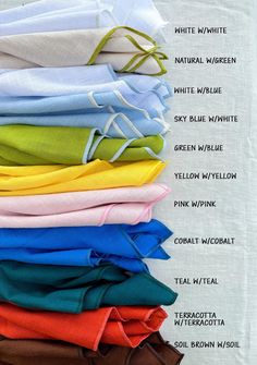 a pile of folded shirts sitting on top of a white table next to each other