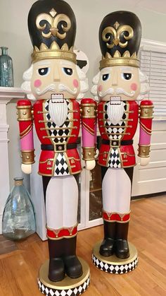 two large nutcrackers are standing next to each other on the wooden floor