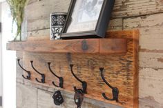 a wooden shelf with hooks and pictures on it