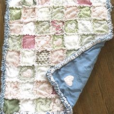 a blanket that is laying on top of a wooden floor next to a blue and white towel