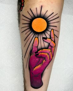 a person with a tattoo on their arm holding up a peace sign and the sun