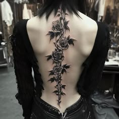 the back of a woman's neck with roses on it and leaves growing out of it