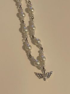 Beaded necklace with an arrangement of white beads and white pearl beads. Includes main charm of heart with angel wings. Can be worn as a choker necklace but is adjustable in length. Heart With Angel Wings, Heart Beaded Necklace, Beaded Necklace White, Angel Heart, Necklace Charms, Necklace White, Heart Beads, Handmade Necklace, White Beads